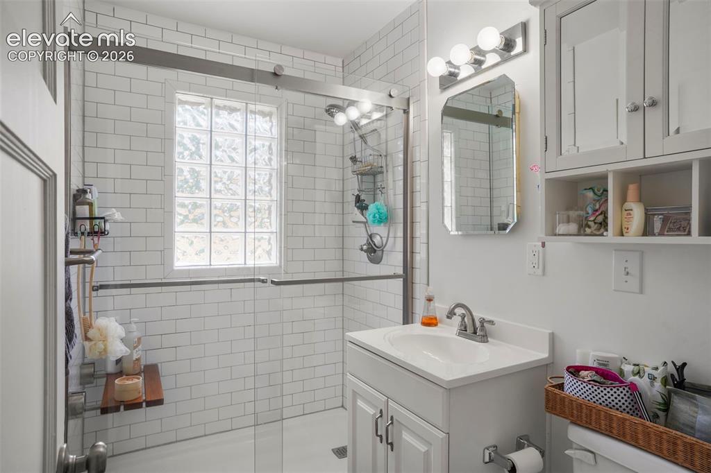 Image 8 of 23: Renovated bathroom with walk in shower and glass shower doors