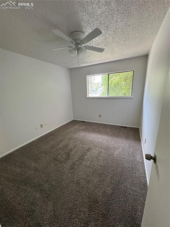 Image 10 of 13: Carpeted spare room featuring ceiling fan and a textured ceiling