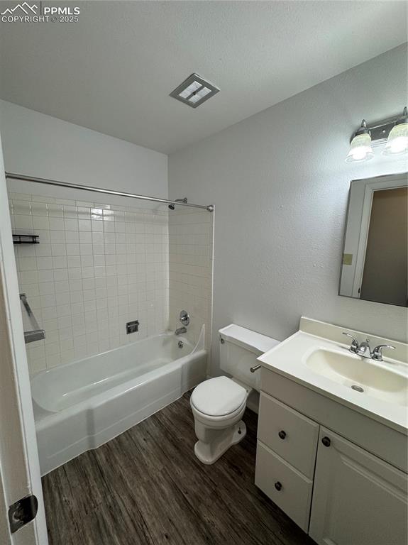 Image 7 of 13: Bathroom with wood finished floors, toilet, vanity, and shower / bath combi
