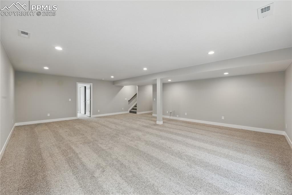 Image 18 of 25: Finished below grade area featuring recessed lighting, light carpet, and st
