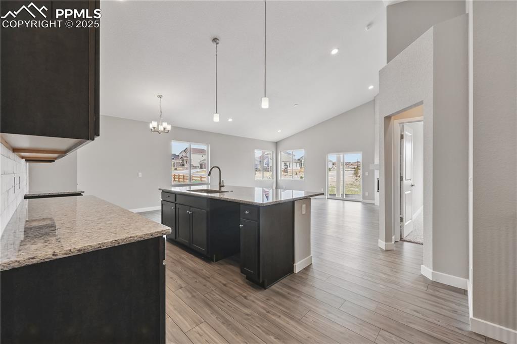 Image 4 of 25: Kitchen with recessed lighting, open floor plan, and decorative light fixtu