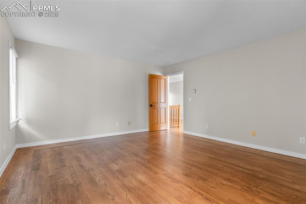 Image 18 of 35: Unfurnished room with wood finished floors and baseboards