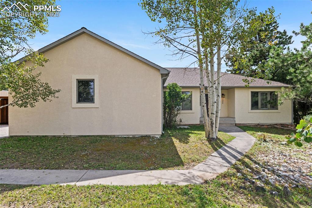 Image 2 of 35: View of front of property with stucco siding and a front yard