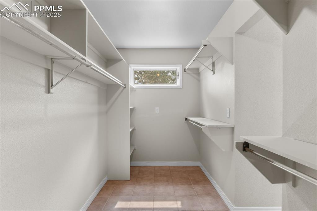 Image 21 of 35: Walk in closet with light tile patterned floors