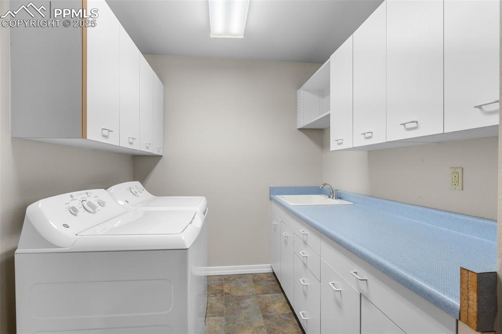 Image 22 of 35: Washroom featuring separate washer and dryer, stone finish flooring, and ca