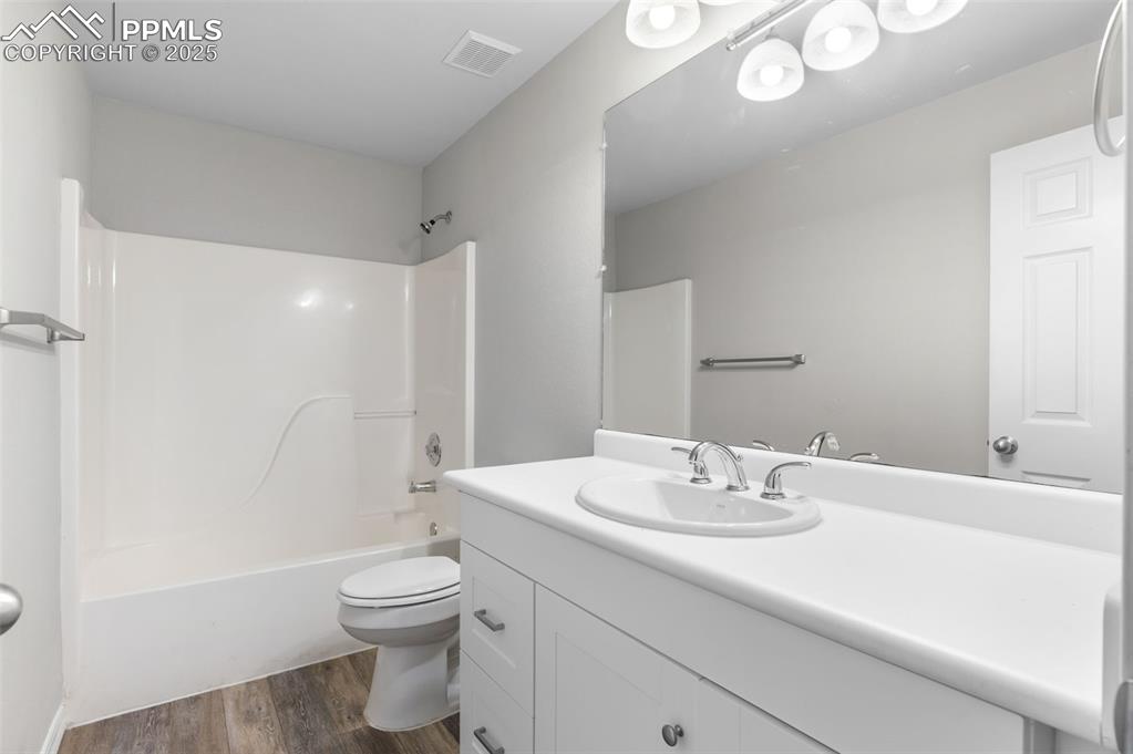 Image 29 of 35: Full bathroom featuring dark wood-style flooring, bathtub / shower combinat