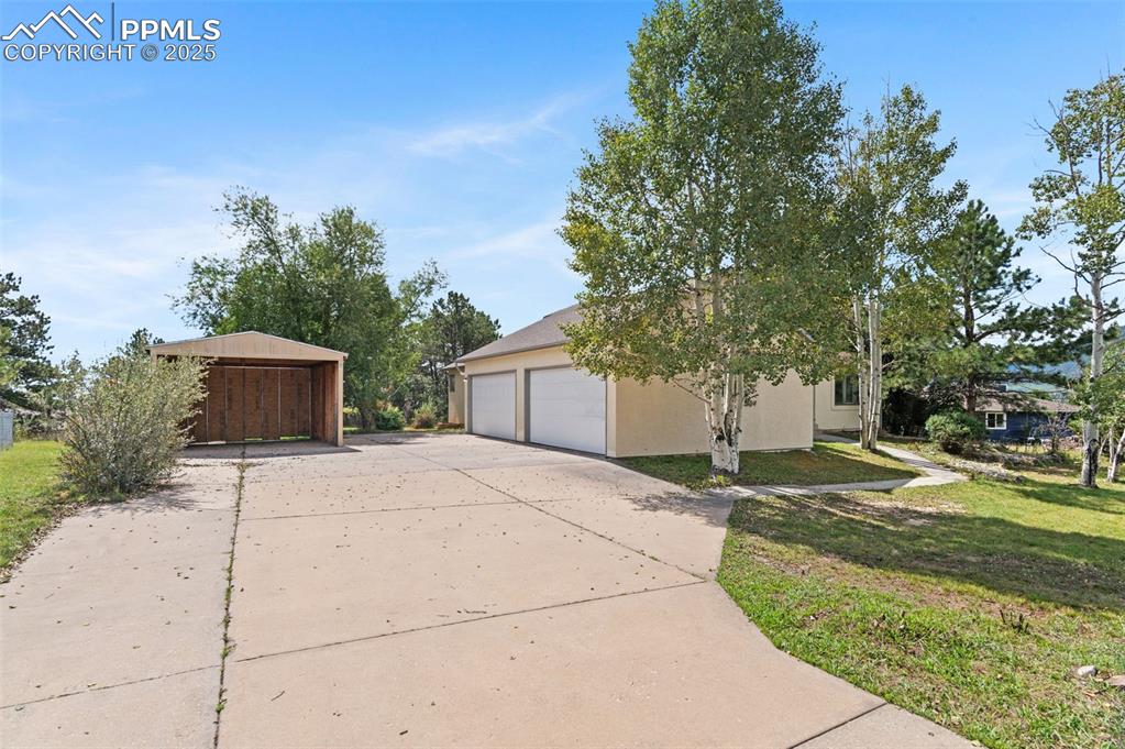 Image 3 of 35: View of side of property featuring an outbuilding, stucco siding, a yard, a