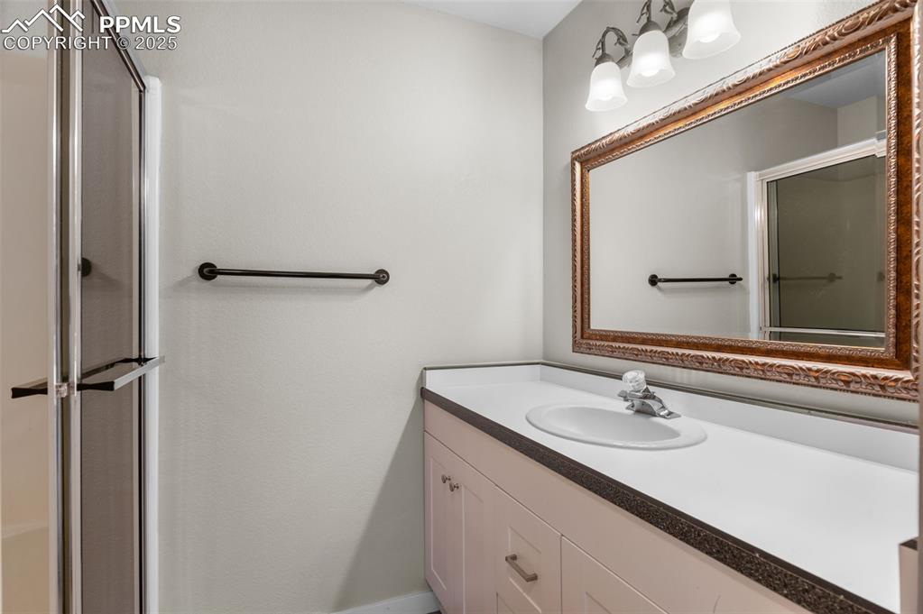 Image 30 of 35: Bathroom featuring a shower stall and vanity