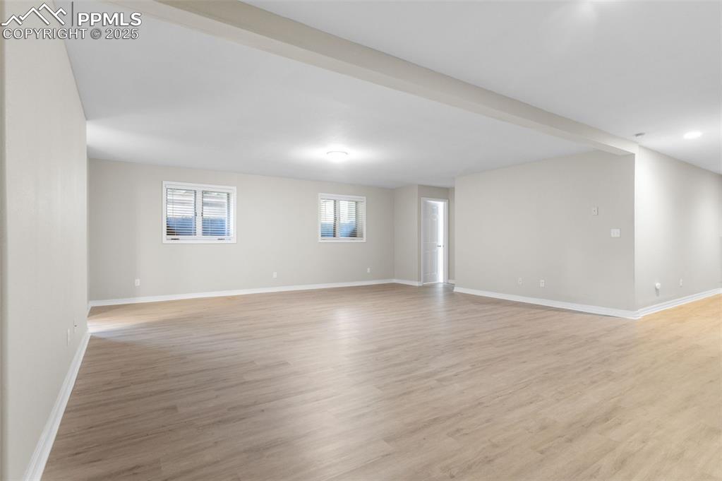 Image 31 of 35: Large room with light wood finished floors