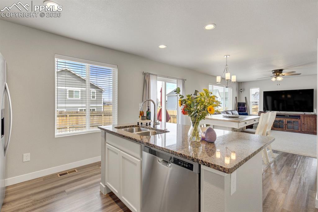 Image 11 of 46: Kitchen with white cabinets, appliances with stainless steel finishes, dark