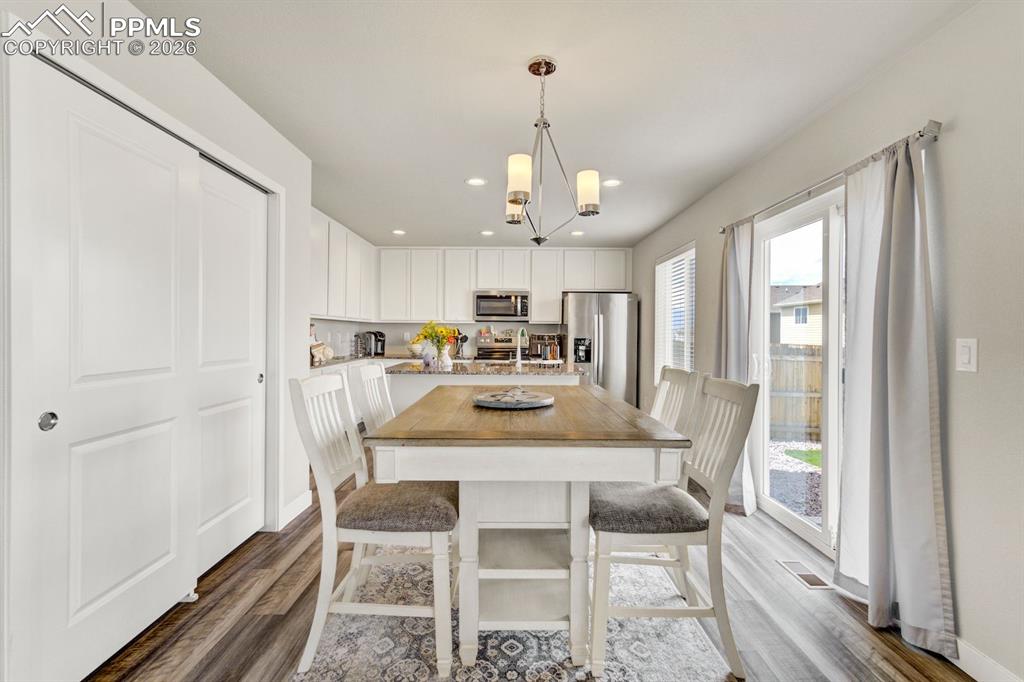 Image 12 of 45: Dining area with recessed lighting, a chandelier, and dark wood-style floor