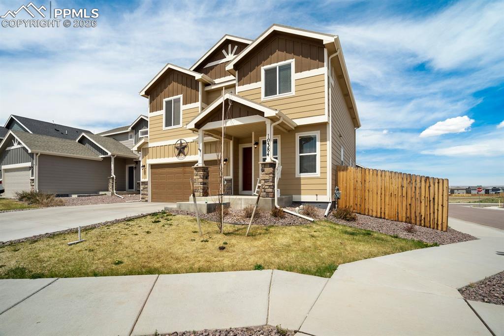 Image 2 of 46: Craftsman-style house featuring board and batten siding, driveway, a garage