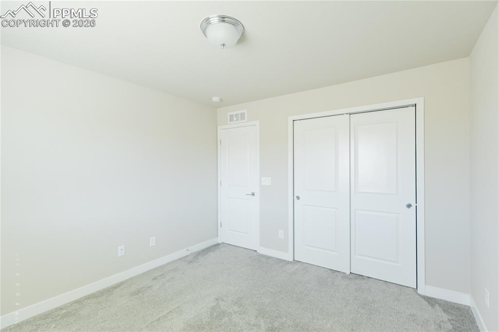 Image 32 of 46: Unfurnished bedroom with light colored carpet and a closet