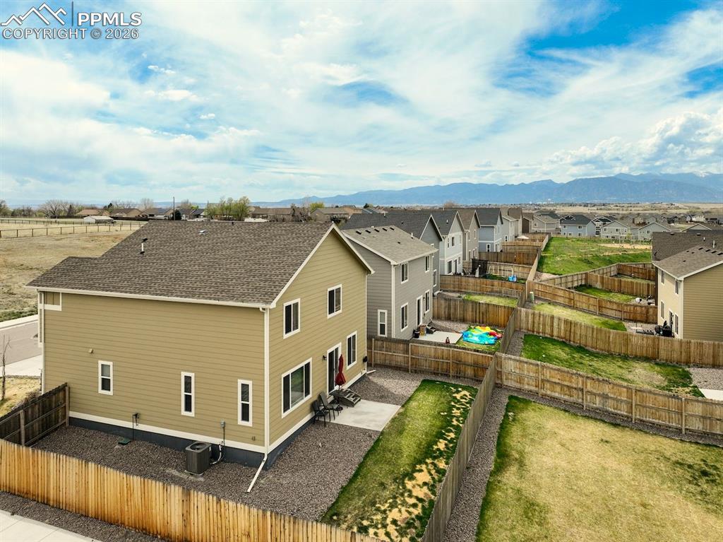 Image 42 of 46: Aerial view of residential area featuring a mountainous background