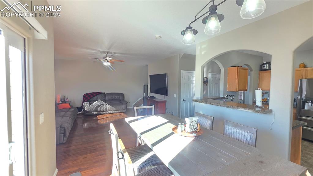 Image 12 of 34: Dining room featuring a ceiling fan, wood finished floors, and arched walkw