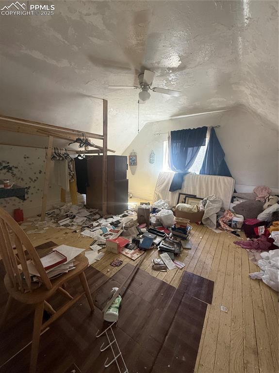 Image 9 of 14: Misc room with lofted ceiling, a textured ceiling, wood-type flooring, and 