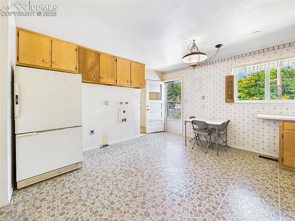 Image 13 of 40: Plenty of cabinets and room for a larger table. Walk-out door to back patio