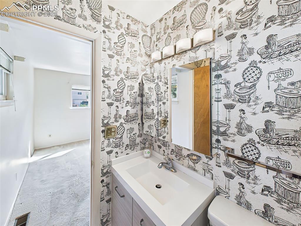 Image 23 of 40: Primary bathroom with newer vanity, lights, updated plumbing and a fun retr