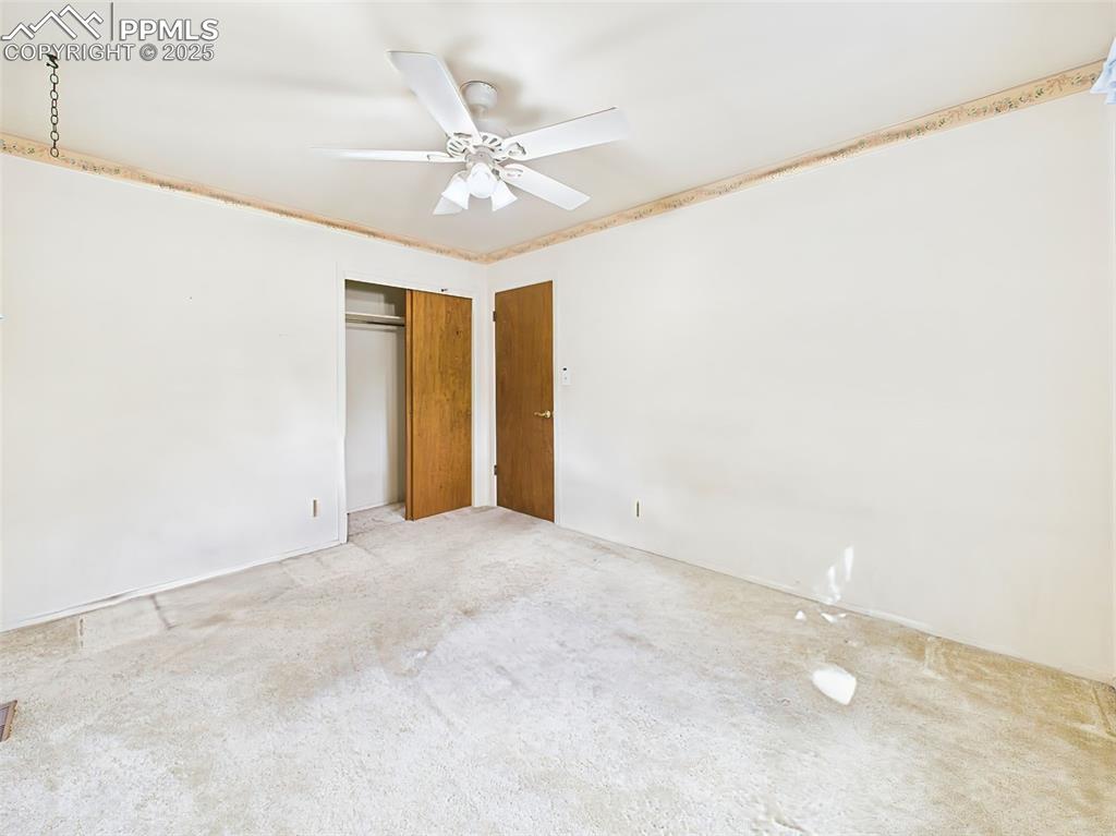 Image 25 of 40: Bedroom #2 has carpet, a large closet and ceiling fan!