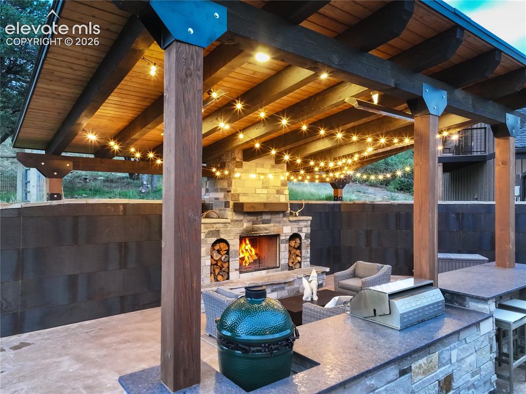 Image 10 of 50: Covered patio w/ fireplace, built-in grill & fridge