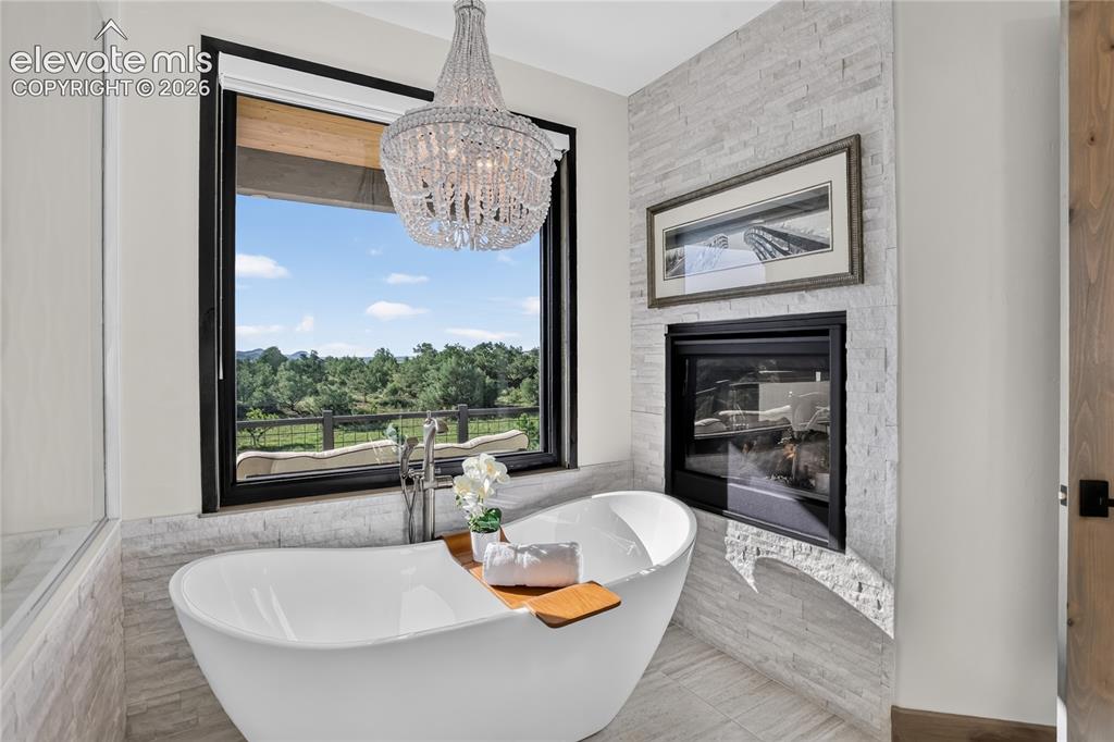 Image 14 of 50: Double-sided fireplace & mountain views