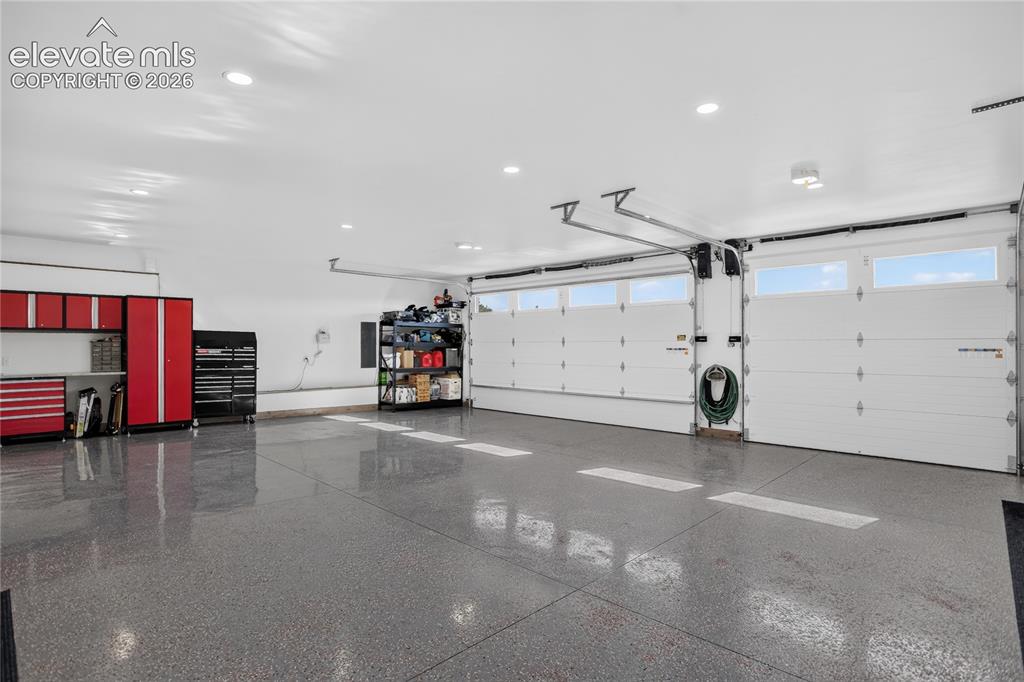 Image 36 of 50: Sloped epoxy flooring & oversized, insulated garage doors