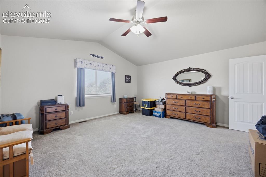 Image 14 of 30: Carpeted bedroom featuring neutral wall tones, a ceiling fan with light fix
