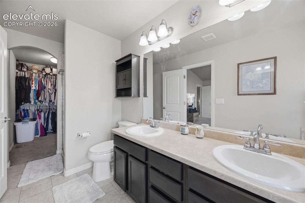 Image 16 of 30: Bathroom vanity with a light-colored countertop, an undermount sink, and a
