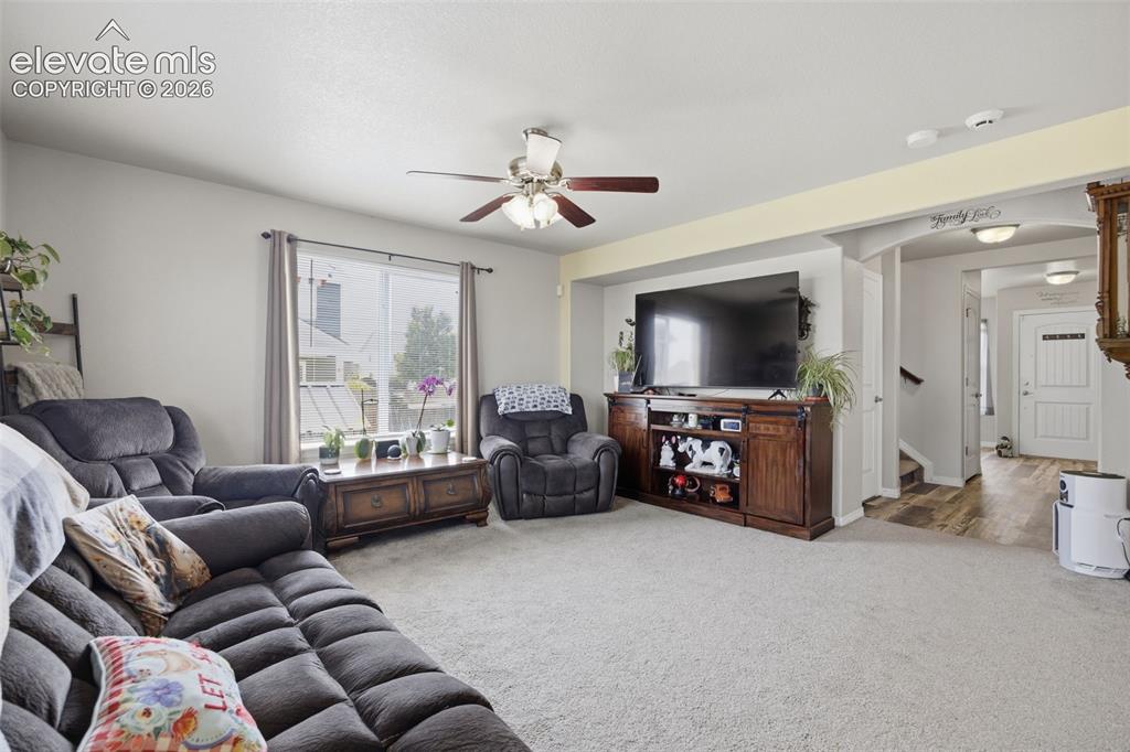 Image 4 of 30: Spacious living area featuring light-toned carpeting and neutral wall color