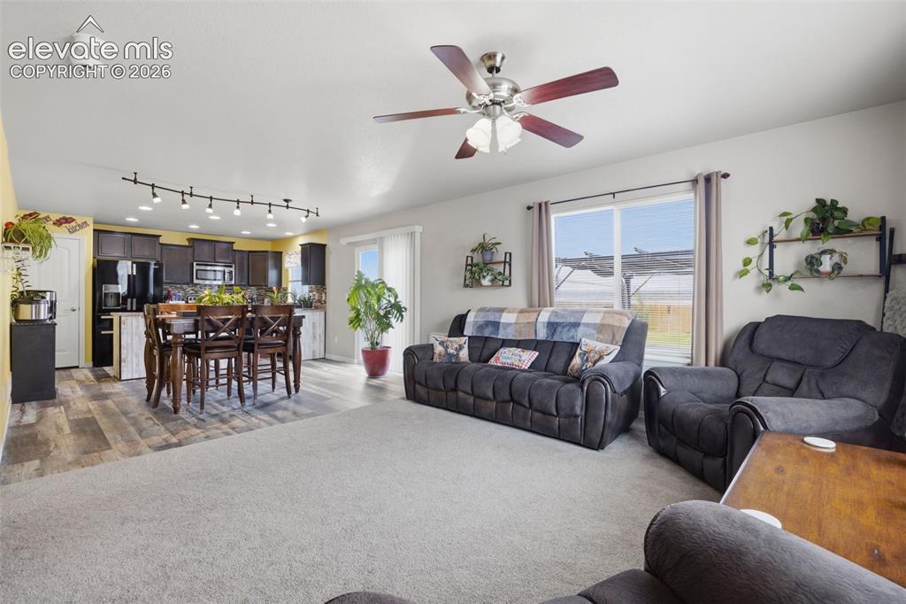 Image 6 of 30: Open-concept kitchen and dining area featuring wood-finish flooring, dark w