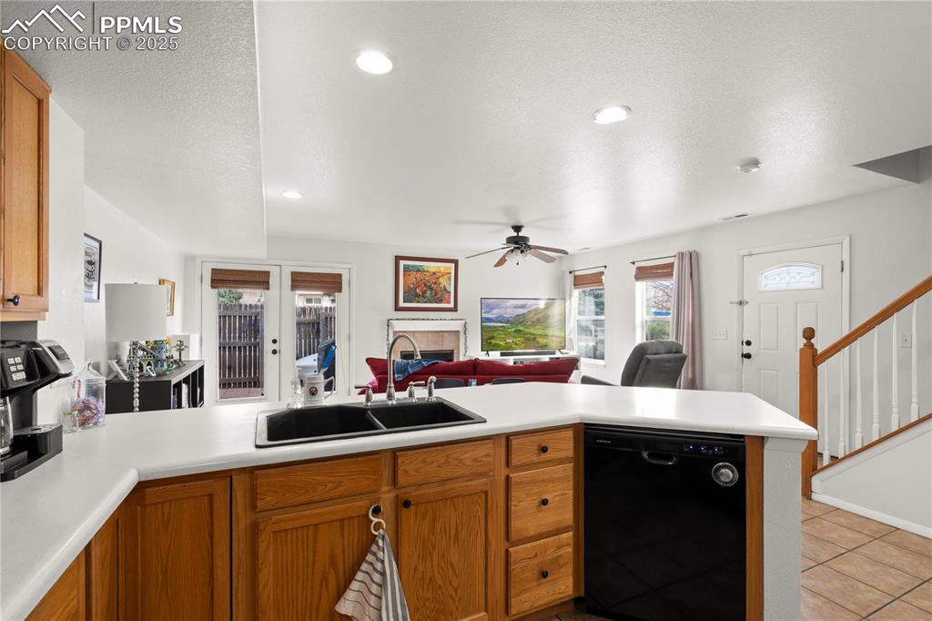 Image 11 of 40: Kitchen with open floor plan, black dishwasher, a peninsula, a fireplace, a