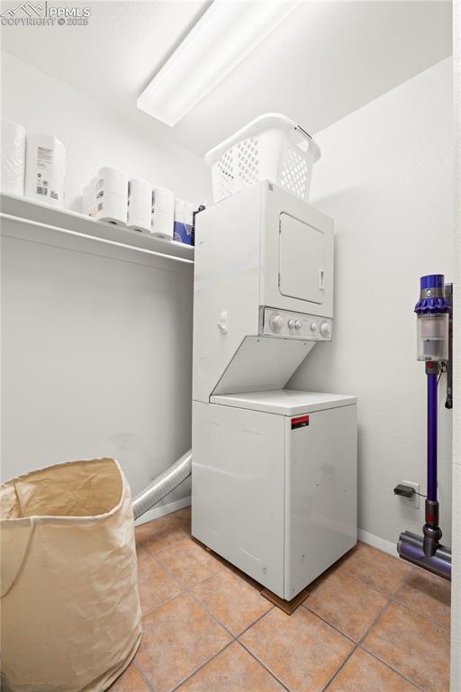 Image 13 of 40: Washroom featuring light tile patterned floors, laundry area, baseboards, a