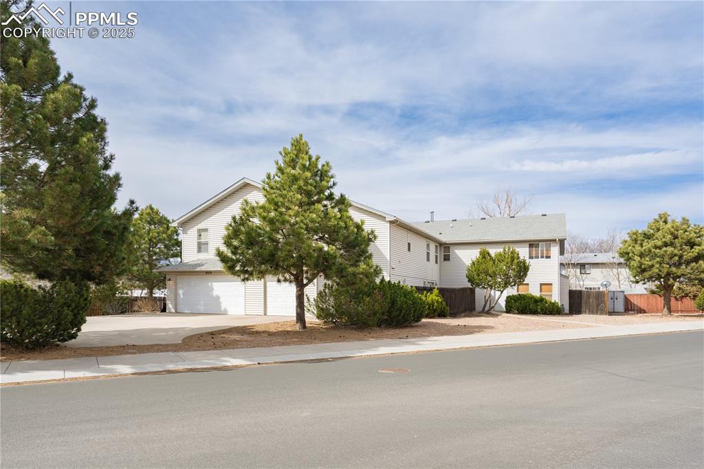 Image 2 of 40: View of front of house featuring driveway, an attached garage, and fence