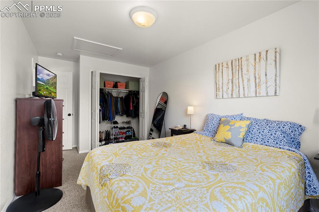 Image 21 of 40: Bedroom with attic access, carpet, and a closet