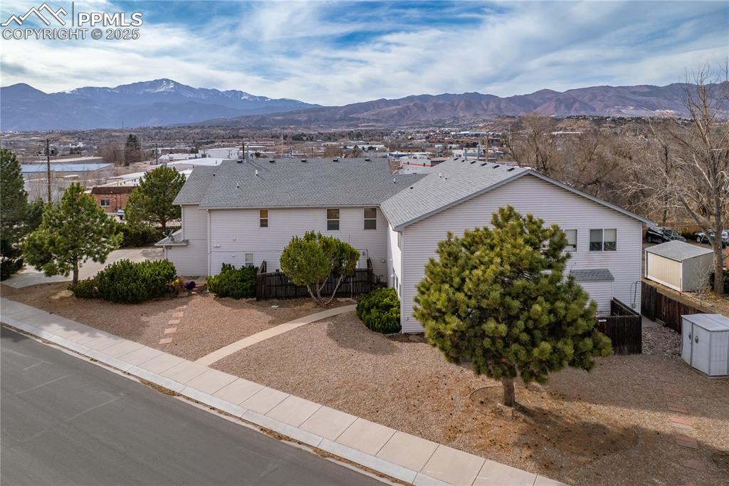Image 40 of 40: View of front of home with a mountain view, a shingled roof, and fence