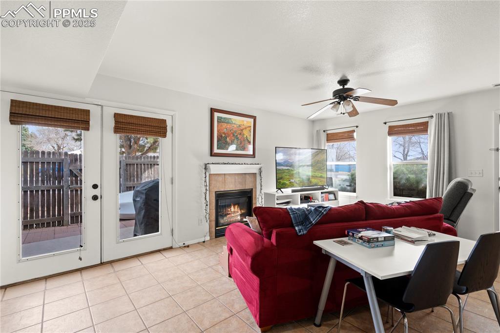 Image 7 of 40: Living area with light tile patterned floors, a textured ceiling, ceiling f