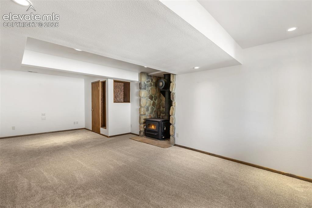 Image 17 of 50: Family room with cozy wood stove.