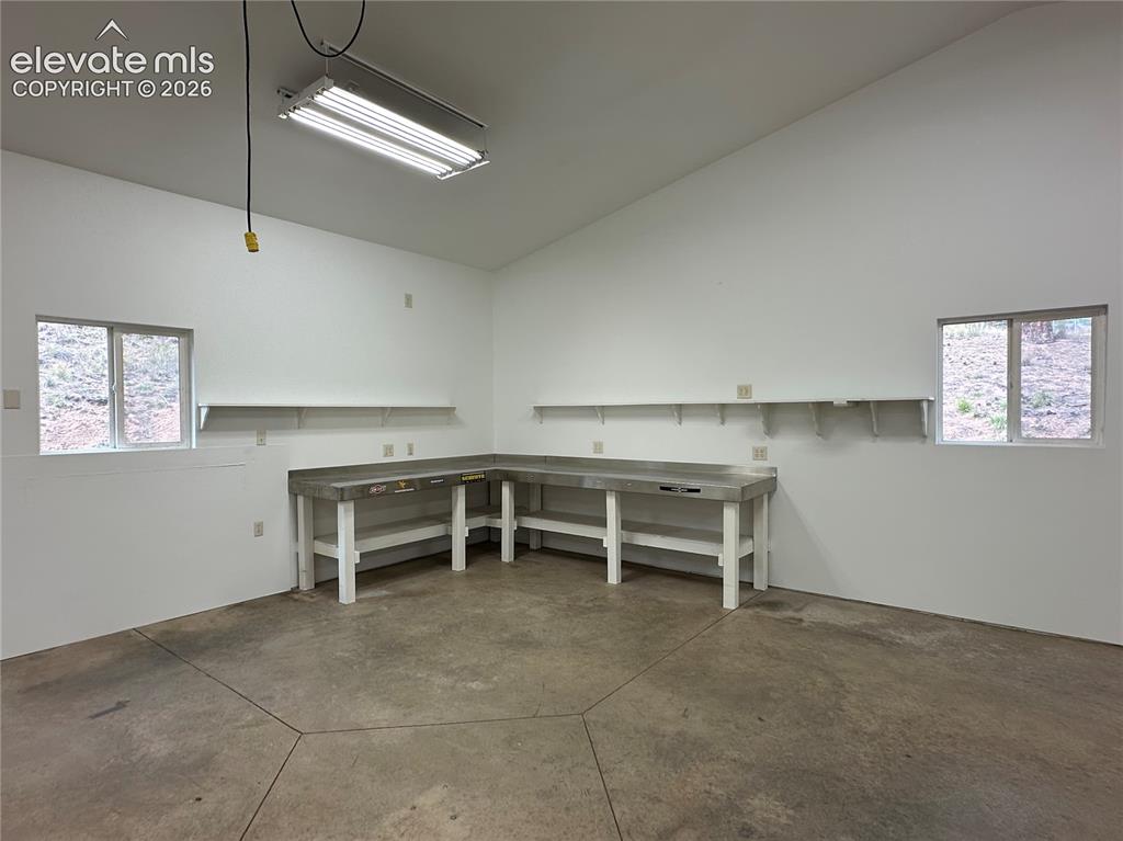 Image 48 of 50: Workbenches and ample electrical outlets. Concrete floor. Excellent lightin