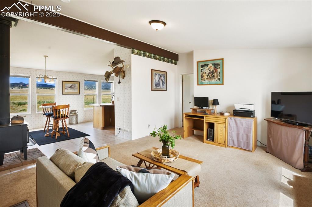 Image 12 of 49: Living room with wallpapered walls and an office area