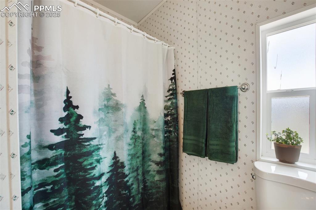 Image 29 of 49: Bathroom featuring wallpapered walls and toilet