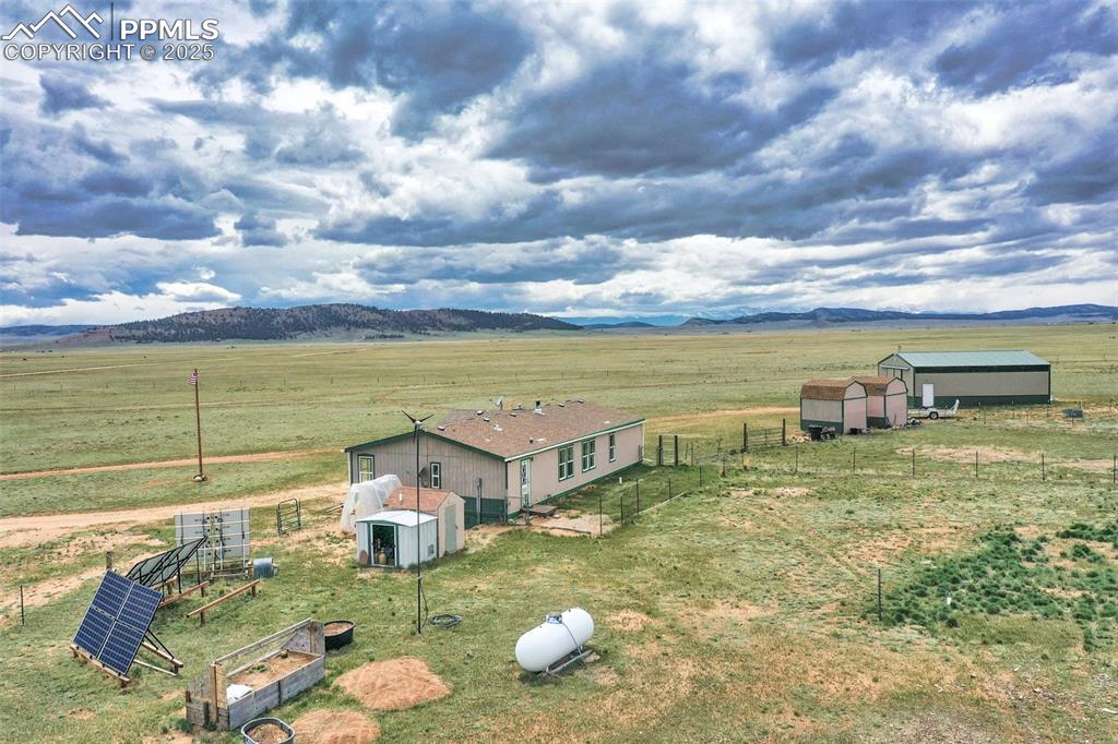 Image 7 of 49: Back yard, solar panels, cold frame, and Distant Mts, the Mosquito Range