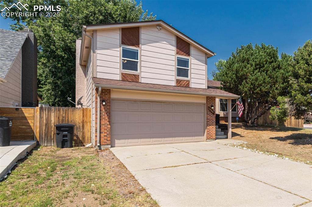 Image 3 of 43: Traditional home featuring brick siding, an attached garage, concrete drive