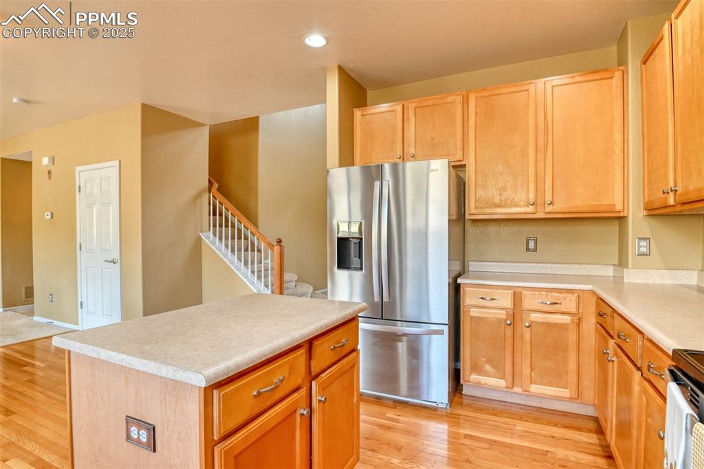 Image 13 of 49: Kitchen featuring stainless steel appliances, light countertops, light wood