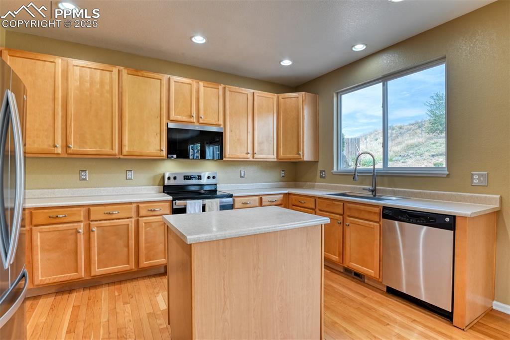 Image 14 of 49: Kitchen with stainless steel appliances, recessed lighting, light wood-type