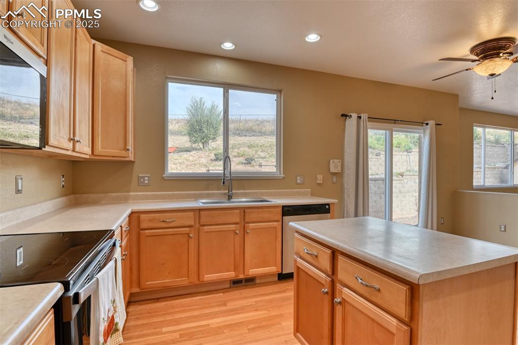 Image 15 of 49: Kitchen featuring stainless steel appliances, light countertops, light wood