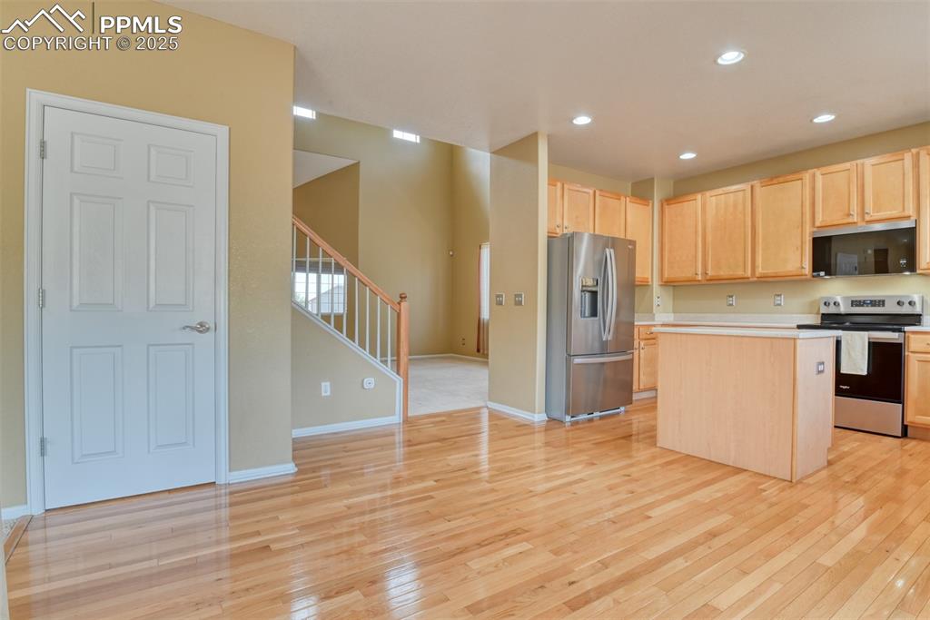 Image 18 of 49: Kitchen featuring light brown cabinetry, appliances with stainless steel fi