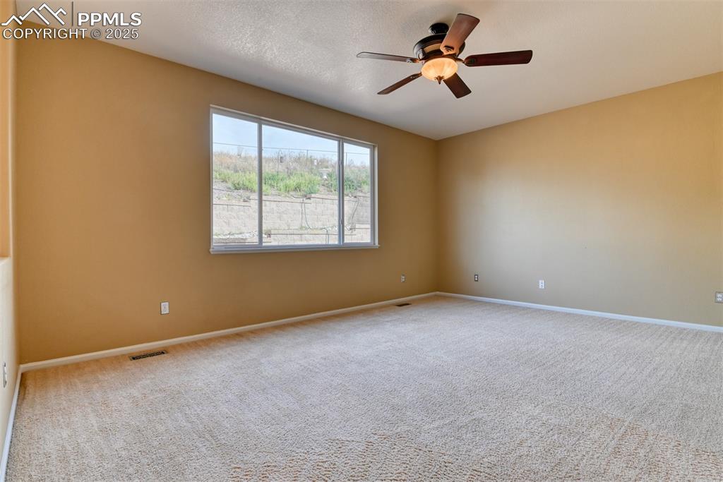 Image 20 of 49: Carpeted spare room with ceiling fan and baseboards