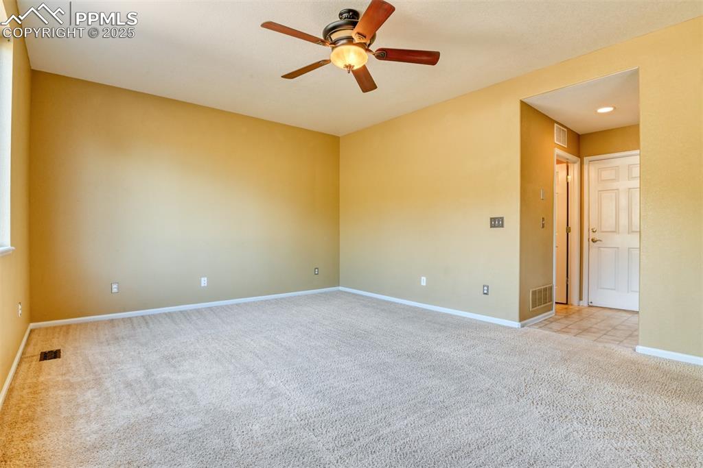 Image 21 of 49: Empty room with light carpet and a ceiling fan