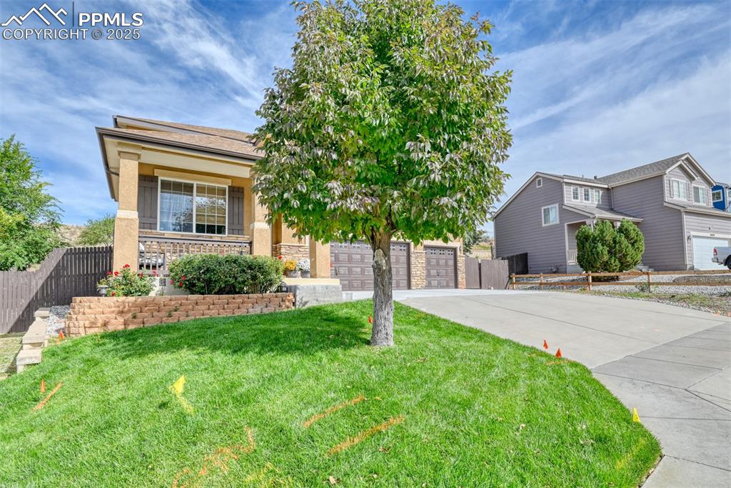 Image 3 of 49: View of front of home with a garage, driveway, a porch, stucco siding, and
