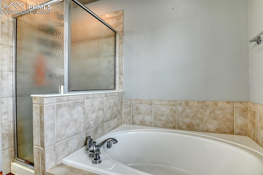 Image 30 of 49: Full bath with a stall shower and a garden tub